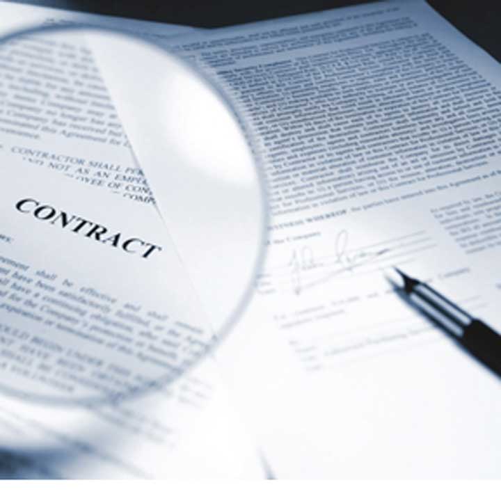 Contract under a magnifying glass with a pen