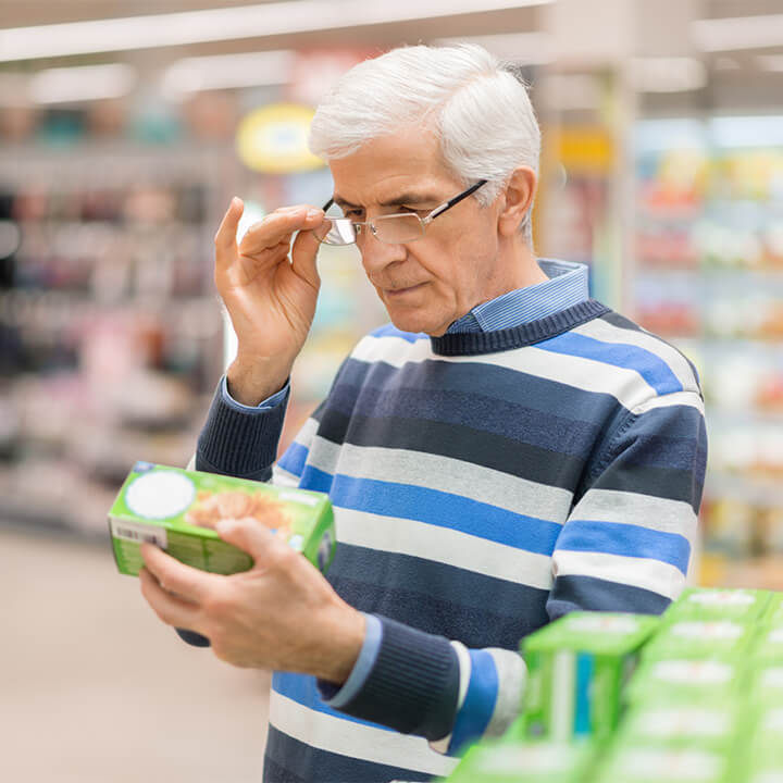 man_reading_food_label_at_a_grocery_store