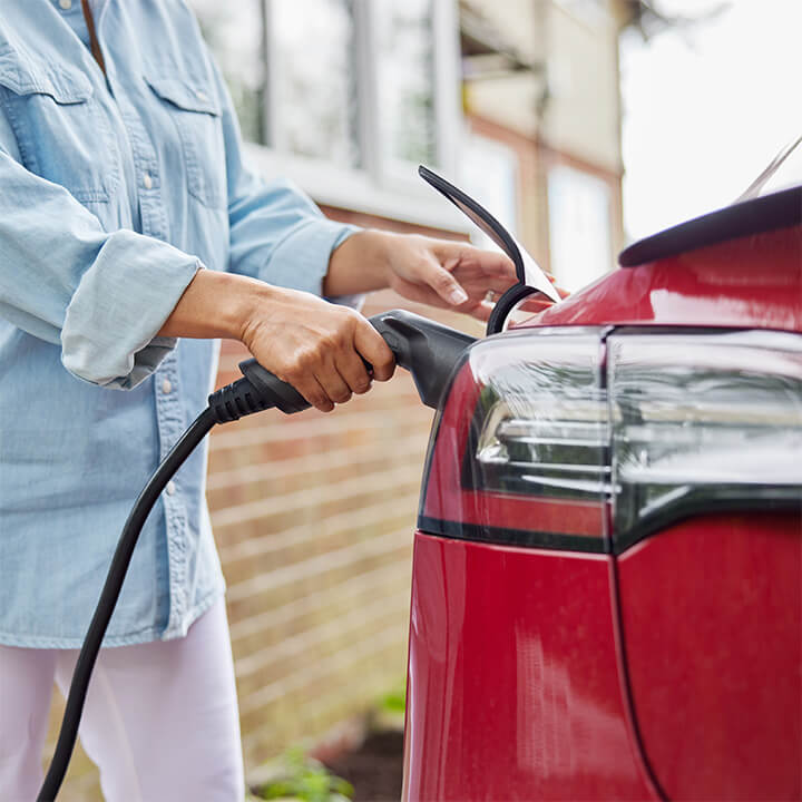 Close Up Of Woman Attaching an EV charge point 720 x 720