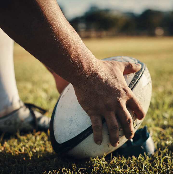 Cropped shot of an unrecognizable rugby player preparing for a kick on the field during the day