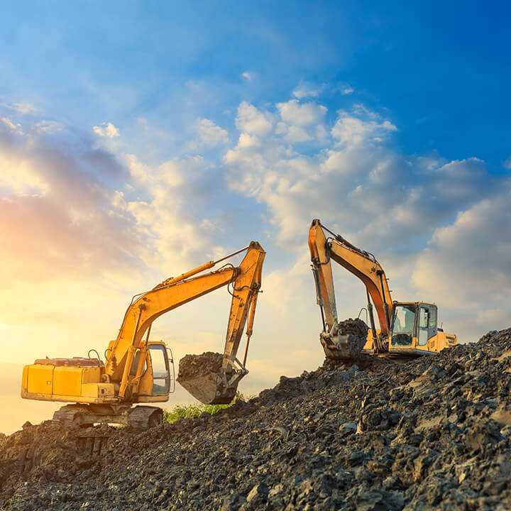 wo-excavators-work-on-construction-site-at-sunset