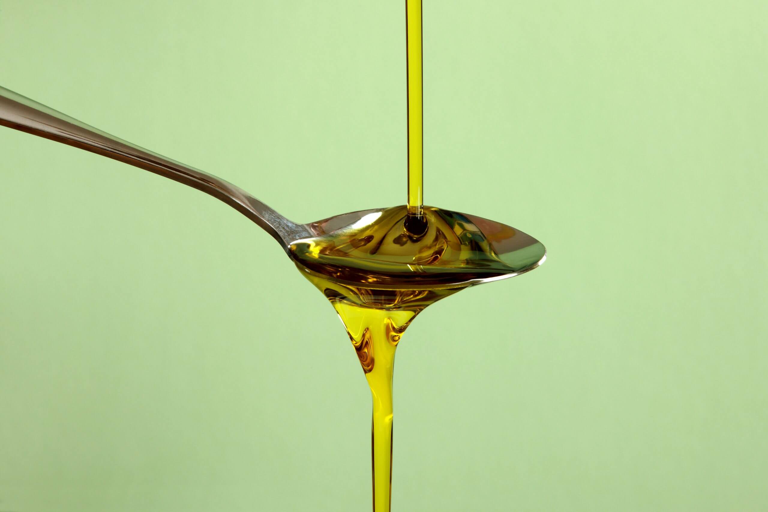 Olive Oil pouring downwards showing viscocity and gravity